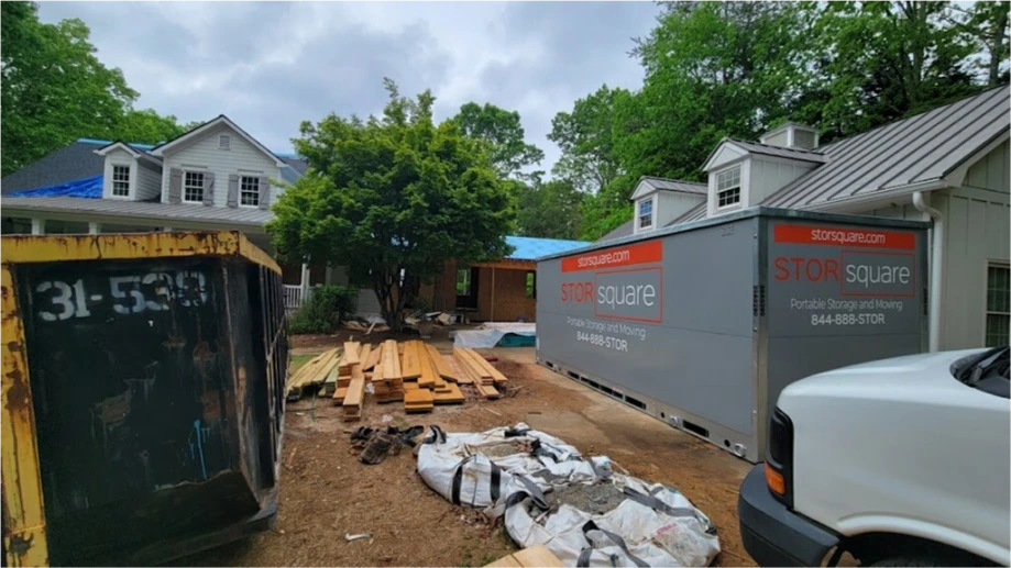 STORsquare portable storage container beside a Bellaire home renovation with lumber and materials nearby.