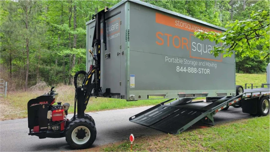 STORsquare portable moving and storage container being placed in Cleveland, NC with the MULE system beside a delivery trailer.