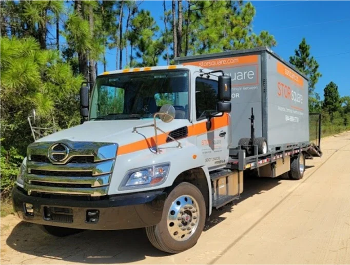 STORsquare delivery truck carrying a portable moving container for residential storage and moving service in Zephyrhills, FL.