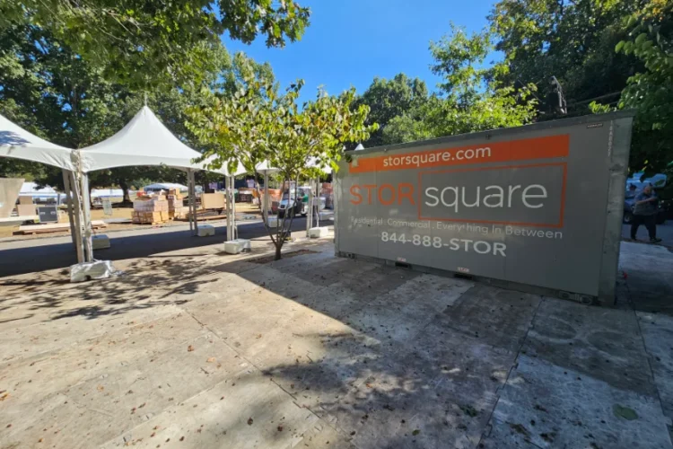 A STORsquare moving container set up beside event tents, showing how moving containers attract shoppers by creating a visible, organized sale area.