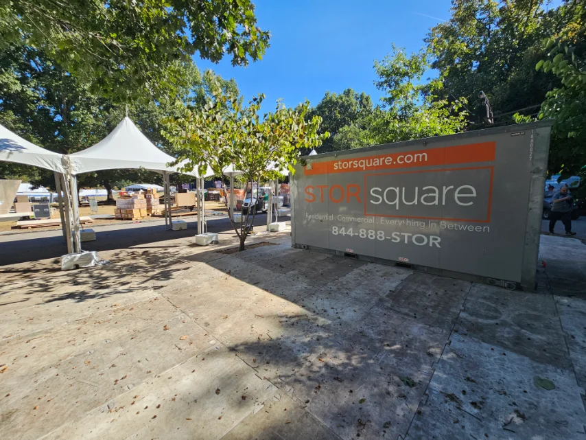 A STORsquare moving container set up beside event tents, showing how moving containers attract shoppers by creating a visible, organized sale area.