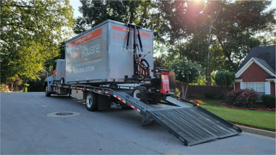 STORsquare moving container loaded on a delivery truck with ramp lowered on a Cinco Ranch residential street.