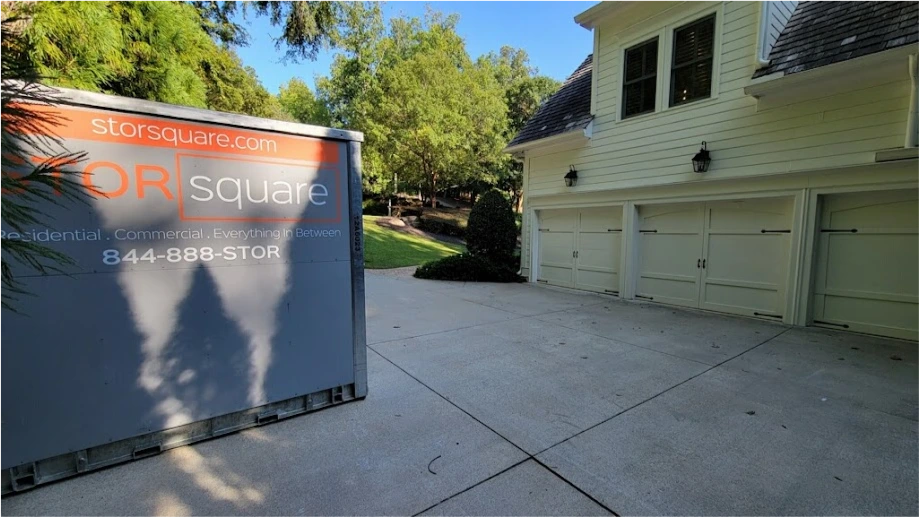 STORsquare moving container placed in a Cinco Ranch driveway beside a multi-car residential garage.