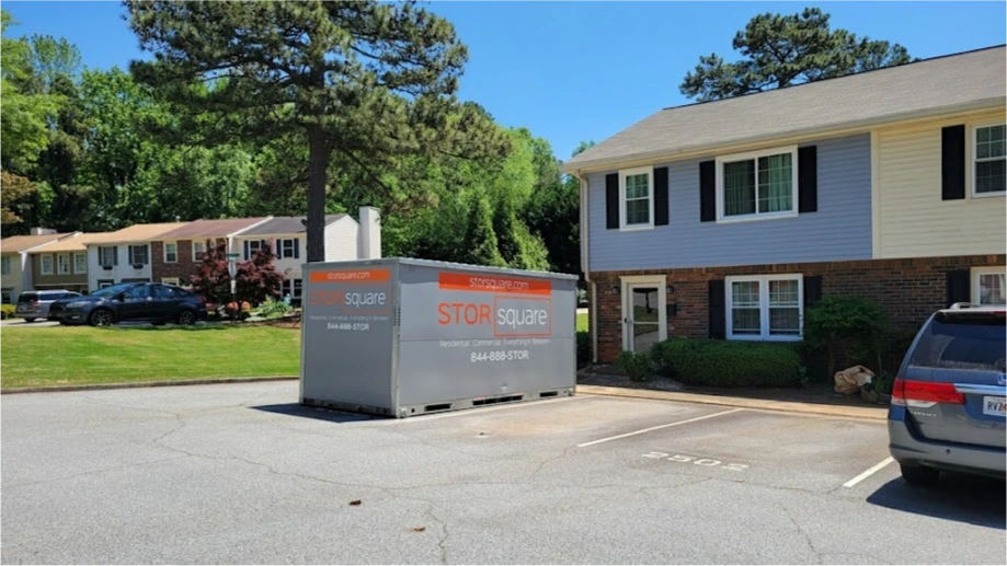 STORsquare portable storage container placed in a Friendswood residential parking area beside apartment-style buildings.