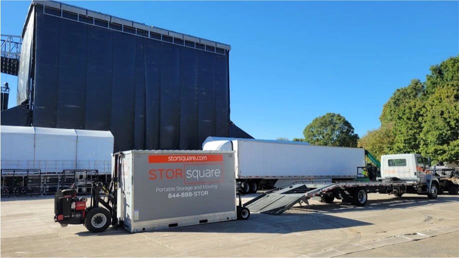 STORsquare container delivery at a League City commercial site with Mule equipment and flatbed truck nearby.