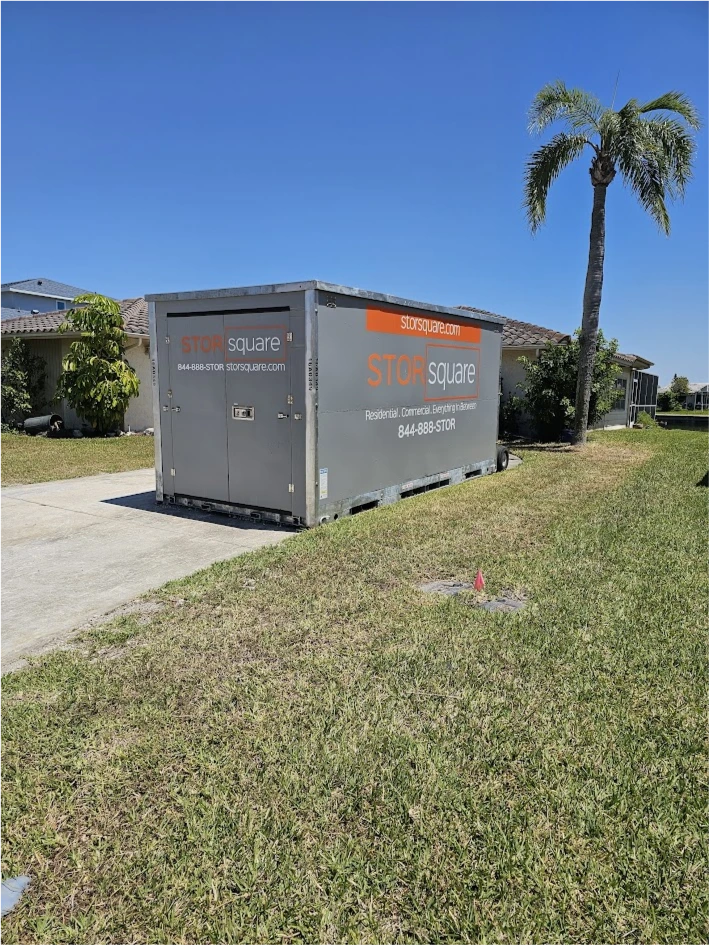 STORsquare portable storage container placed on a League City driveway beside a palm tree and residential homes.