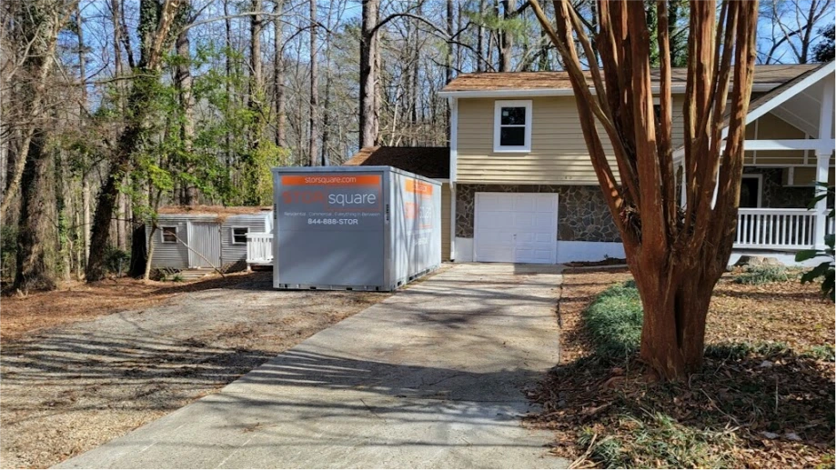 STORsquare storage container placed in a Memorial driveway beside a wooded residential home.