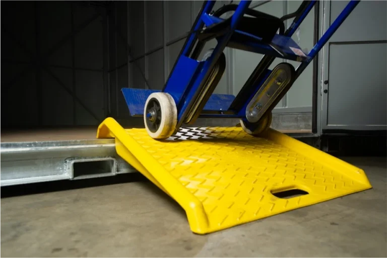Blue hand truck rolling over a yellow ramp into a STORsquare moving container in Rosenberg.