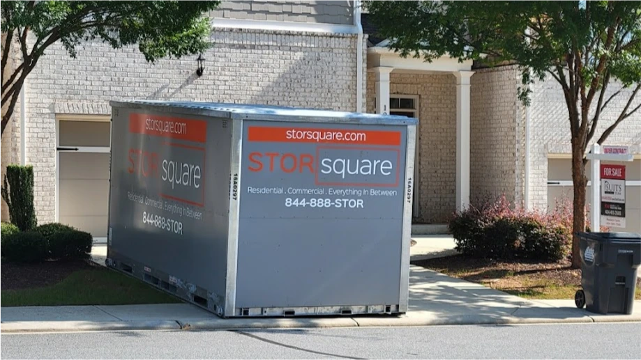 STORsquare storage container placed in a Spring townhome driveway with a for-sale sign nearby.