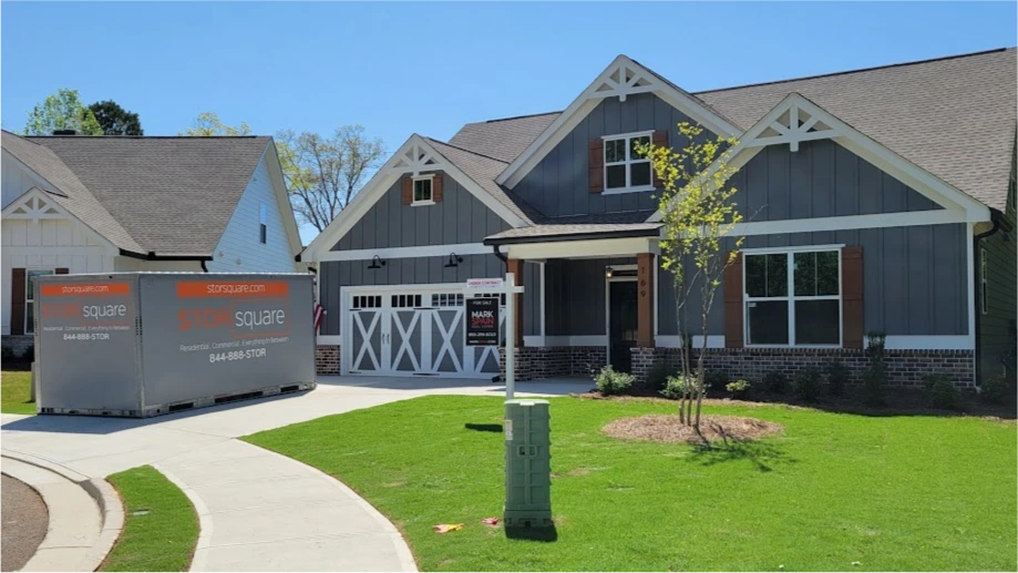 Two STORsquare containers on a driveway outside a gray home in The Woodlands.