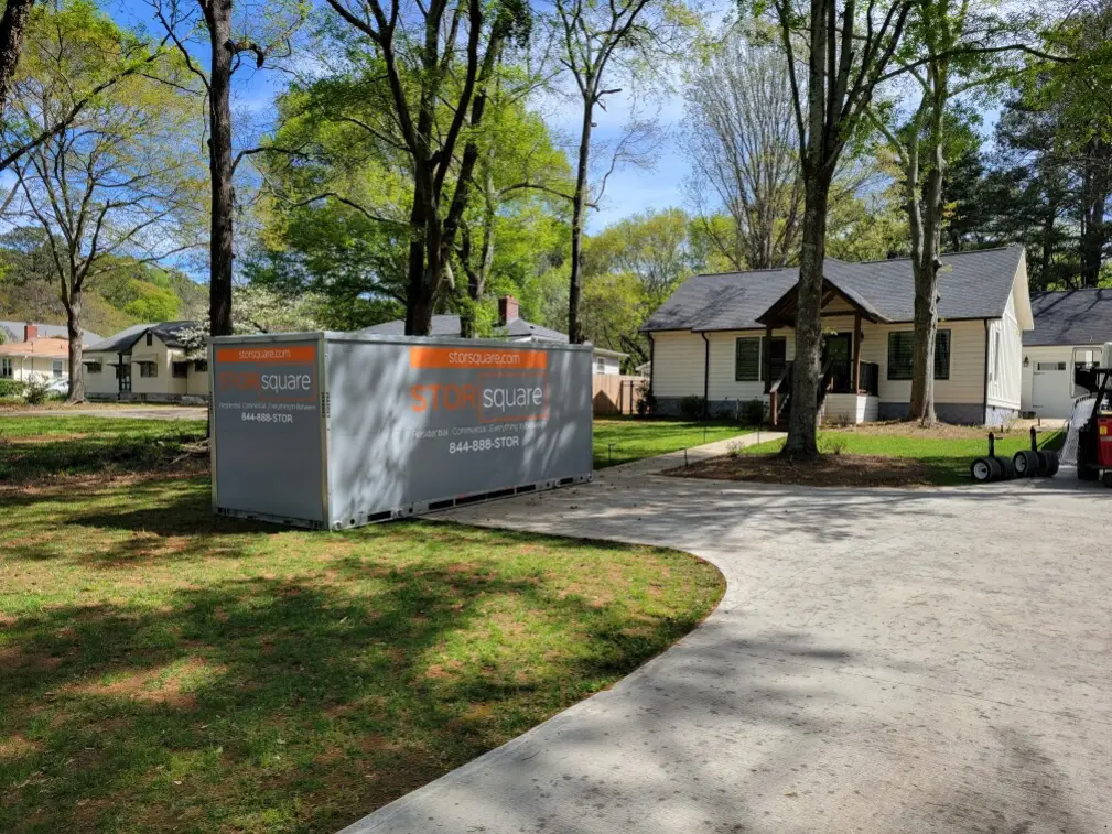 Portable storage container in a driveway showing what to pack first for a long-distance move