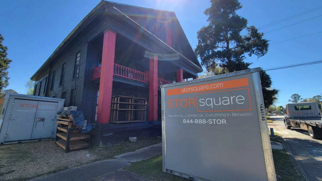 Mobile storage for moving containers placed outside a historic home during an interstate relocation.
