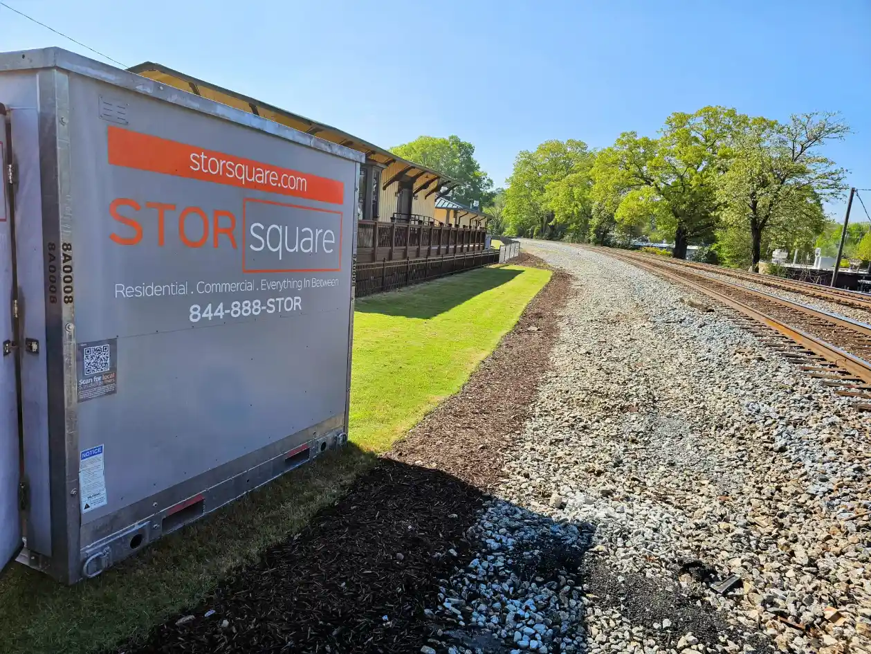 STORsquare portable storage container placed beside a commercial property and railroad tracks.