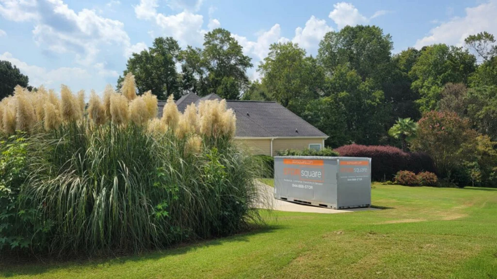 Portable storage container placed on a residential property with open yard space and landscaping