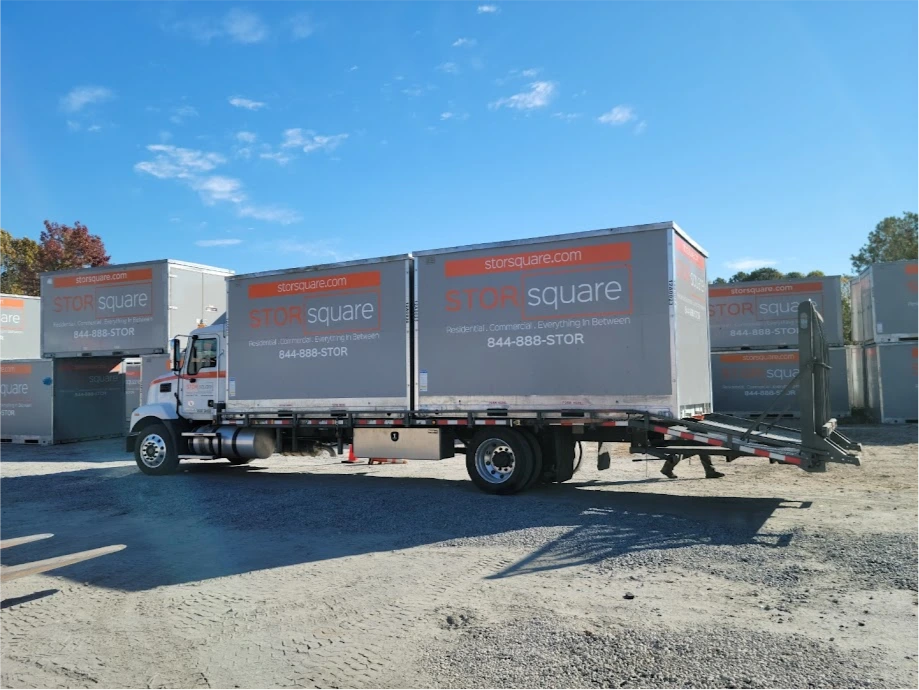 STORsquare truck carrying two portable storage containers at a storage lot in Fort Meade, FL.