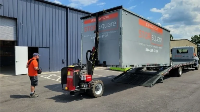 STORsquare moving container in Sweetwater being unloaded from a delivery truck beside a commercial building.