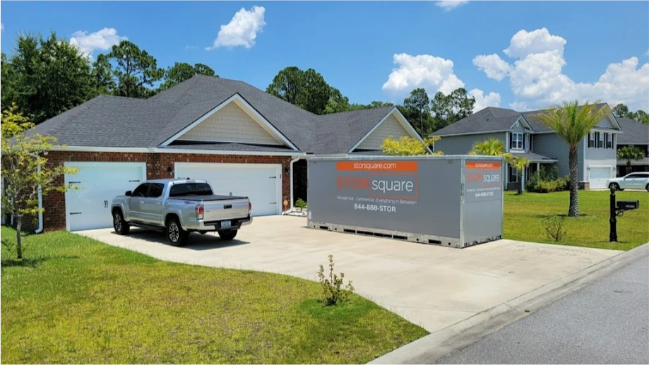 STORsquare portable storage container placed in a Kodak driveway beside a home and parked truck.