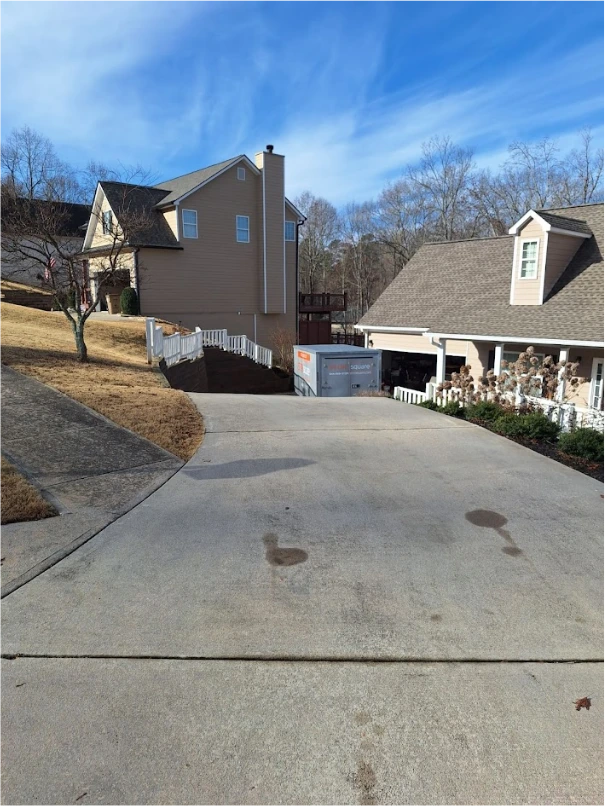 STORsquare portable storage unit placed at the bottom of a sloped driveway beside a Harriman home.