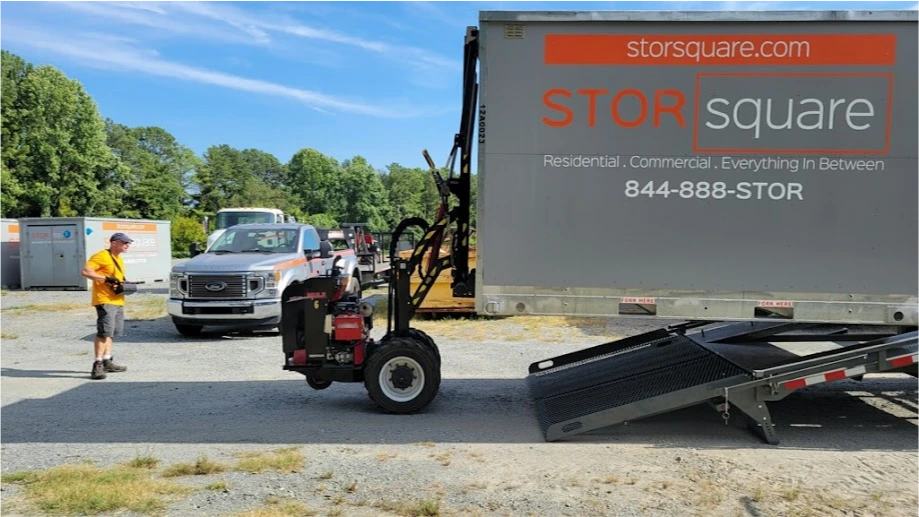 STORsquare portable storage container being loaded onto equipment in an open yard in Lexington.