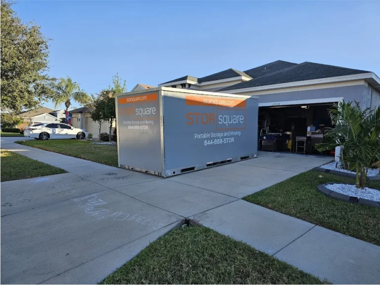 STORsquare portable storage container placed on a residential driveway beside an open garage in Fort Meade, FL.