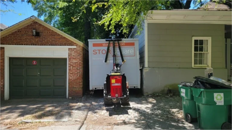 STORsquare storage container being positioned in a tight driveway between homes in Holden Heights.