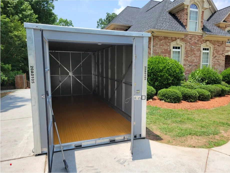Open STORsquare portable storage container with an empty interior placed in a residential driveway for customers in Amherst, TN.
