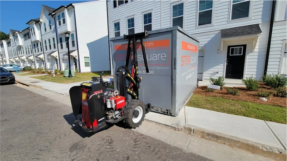 STORsquare portable moving container being positioned beside townhomes for customers in Edgewood, FL.