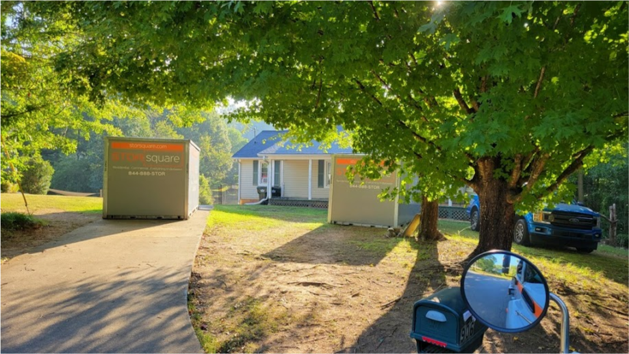 Two STORsquare portable storage containers positioned beneath mature trees outside a residential home in Madison, GA.